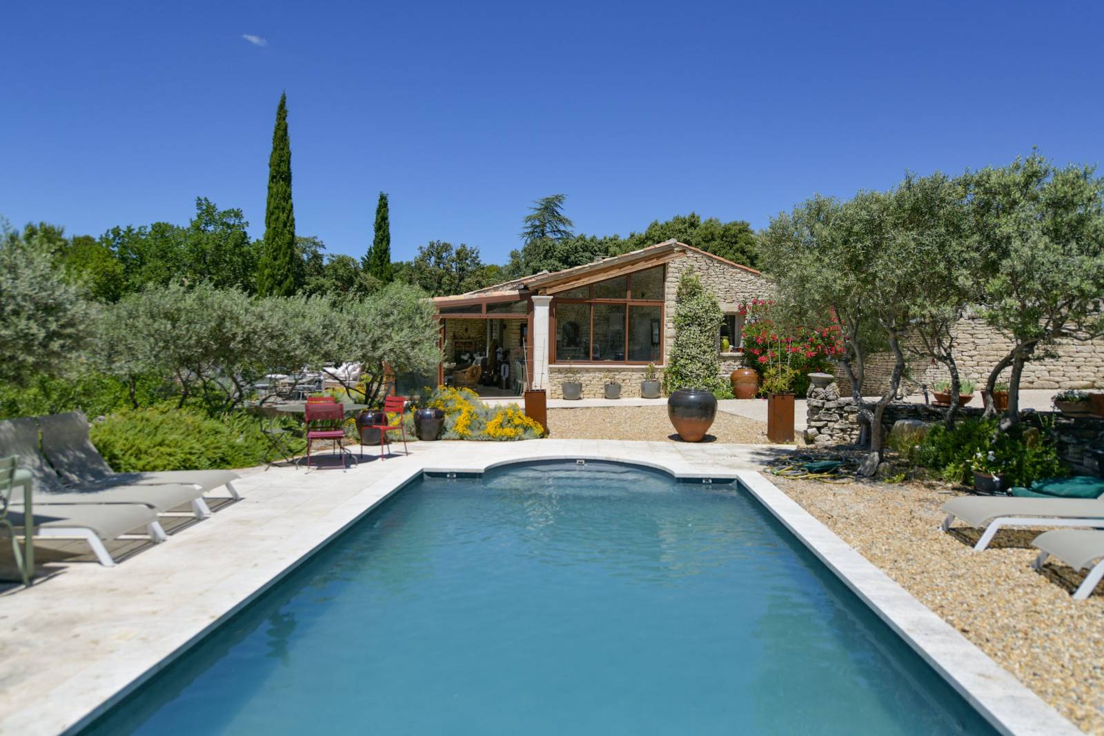 Near the village of Gordes, charming 4-bedroom house with exposed stone walls, for sale, on a wooded lot featuring a swimming pool and a pool house.
