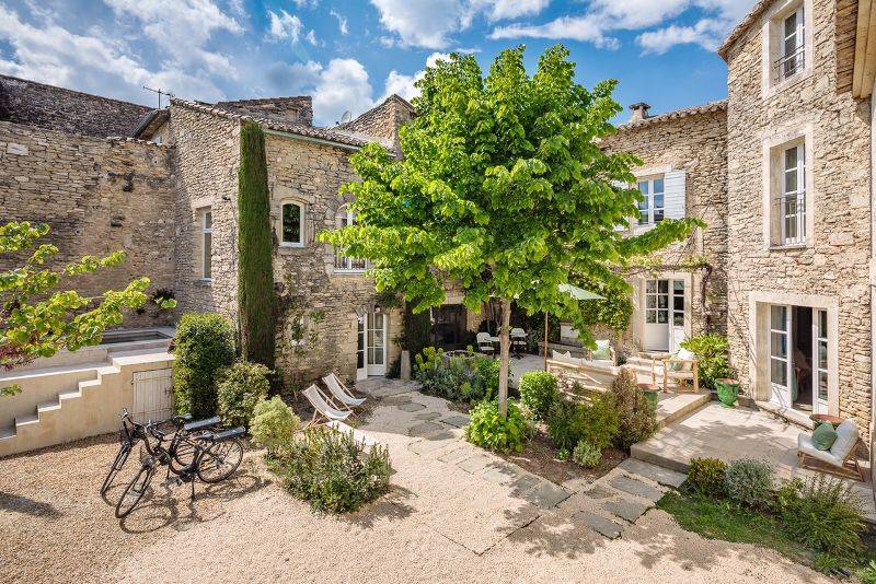 In Gordes, in the heart of a sought-after hamlet, for sale a superb restored 18th-century stone house with two outbuildings set in an enclosed garden featuring a pond.