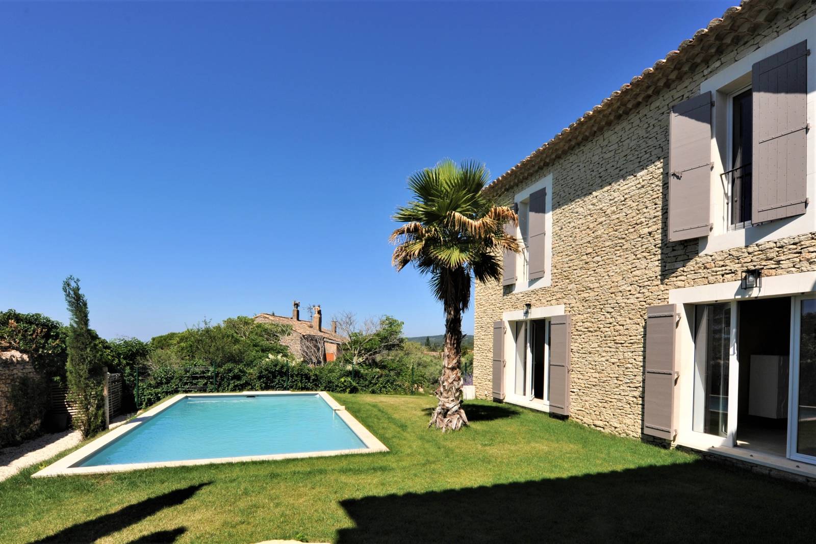 Contemporary stone villa within walking distance of Gordes, with heated pool, panoramic views and elegant outdoor living spaces.