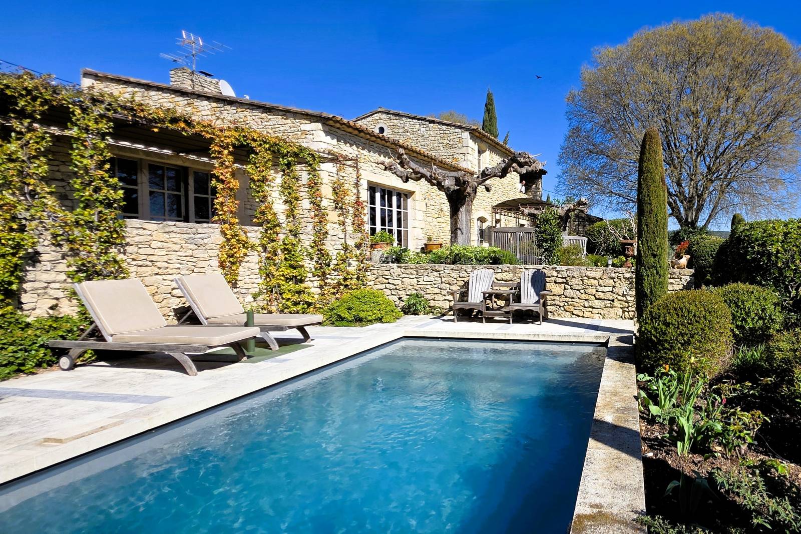 Near the village of Gordes, elegant restored stone hamlet house with terraces, swimming pool, and views of the Luberon.