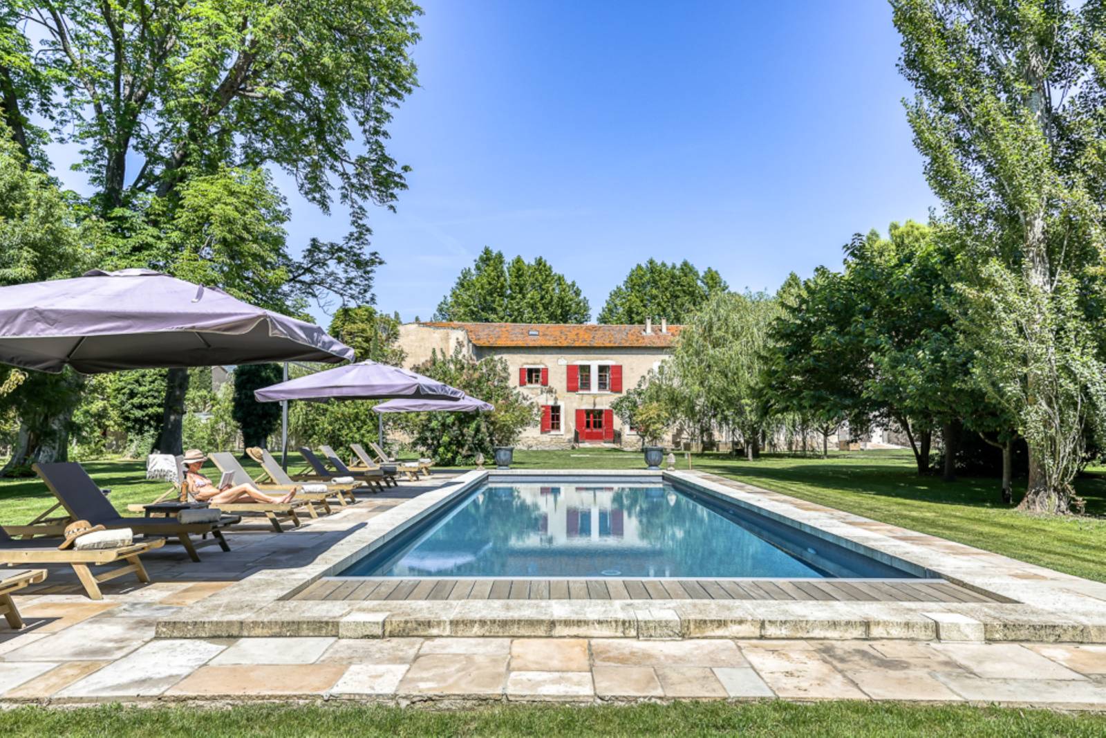 For rent near L’Isle-sur-la-Sorgue, beautifully renovated Mas with high-end amenities, 11 bedrooms, swimming pool and riverfront setting.