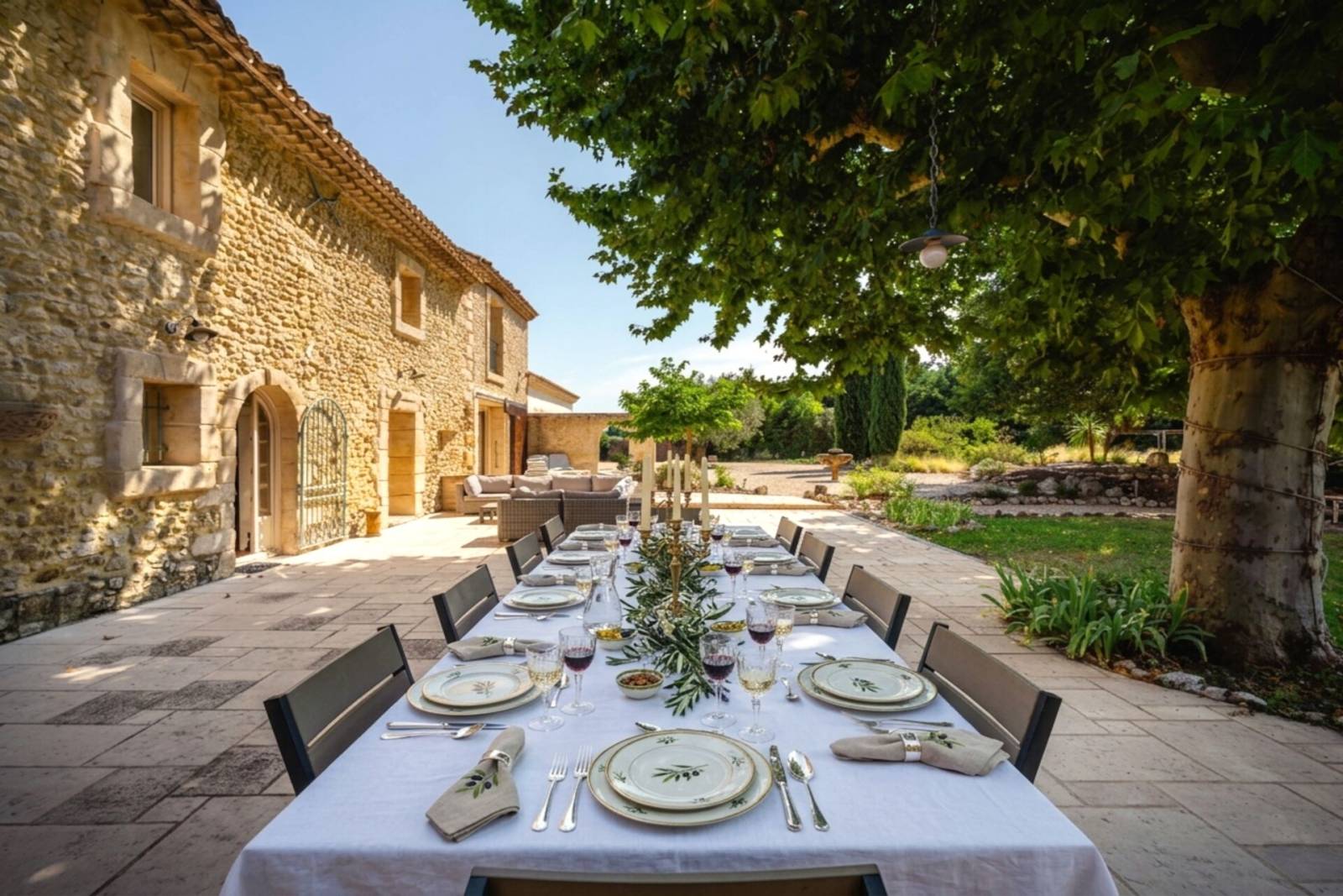 Provencal Art de Vivre: Elegant dining area on the spacious terrace, perfectly shaded by a century-old oak tree for your summer entertaining.