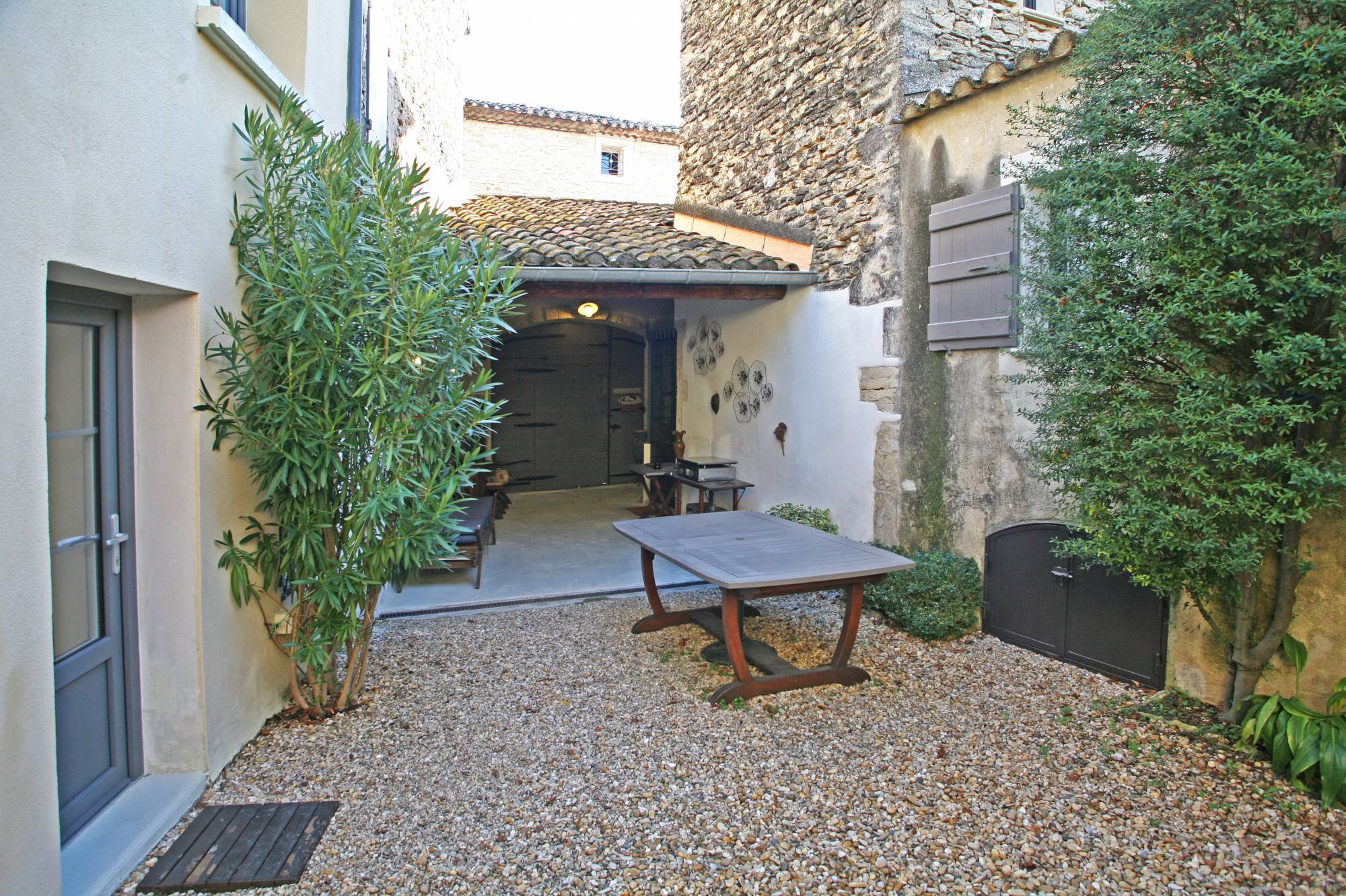 In the heart of the charming village of Cabrières d'Avignon, it is a magnificent wooden gate which opens onto a pretty courtyard