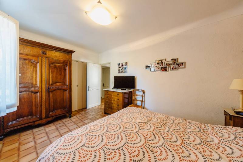 Comfortable and spacious bedroom with traditional floor tiles, perfect for a master suite or an independent guest room.