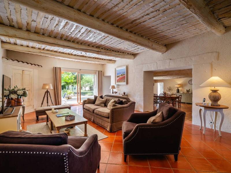 Warm Reception Room: Vast living area featuring traditional Provencal ceilings, exposed beams, and direct access to the outdoors.