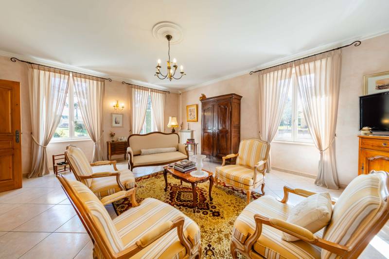 Bright and spacious Provençal living room (salon) with a fireplace and traditional furnishings.
