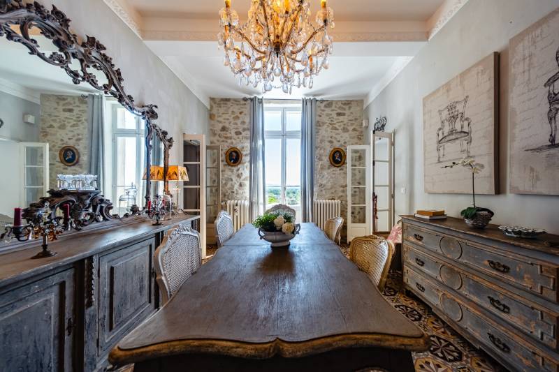 Elegant dining hall with historical character, bathed in natural light through large traditional windows.