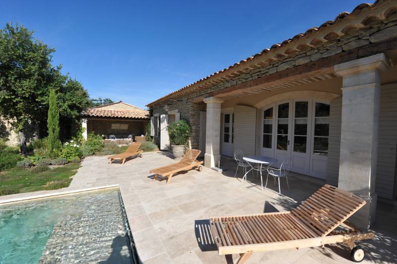 Charming architect-designed stone villa at the foot of Gordes with swimming pool, large wooded garden and high-end amenities.