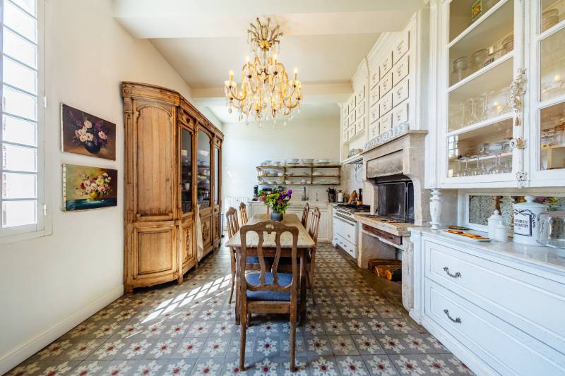 Country-style dining kitchen blending modern high-end appliances with authentic Provencal charm and terrace access.