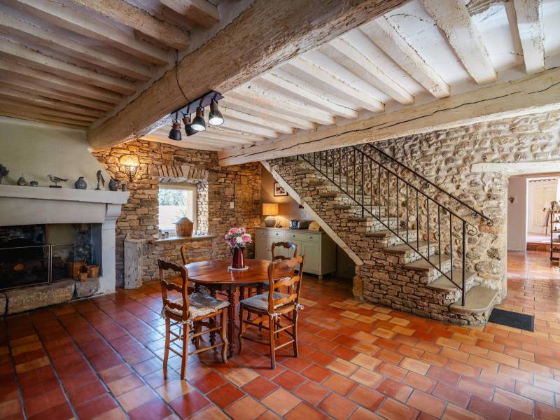 Preserved Authenticity: Character-filled dining room highlighting exposed stonework, terracotta flooring, and a handcrafted staircase.