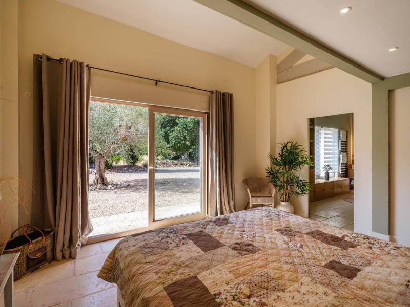 Ground-Floor Master Suite: Luminous bedroom opening directly onto the garden and the surrounding nature.