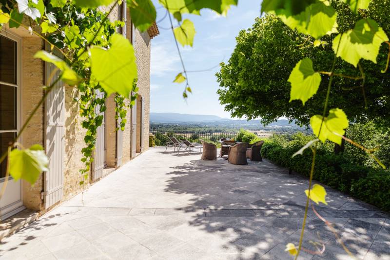 For rent in Gordes, stone Bastide in an elevated position with Luberon views, spacious grounds, and pool.