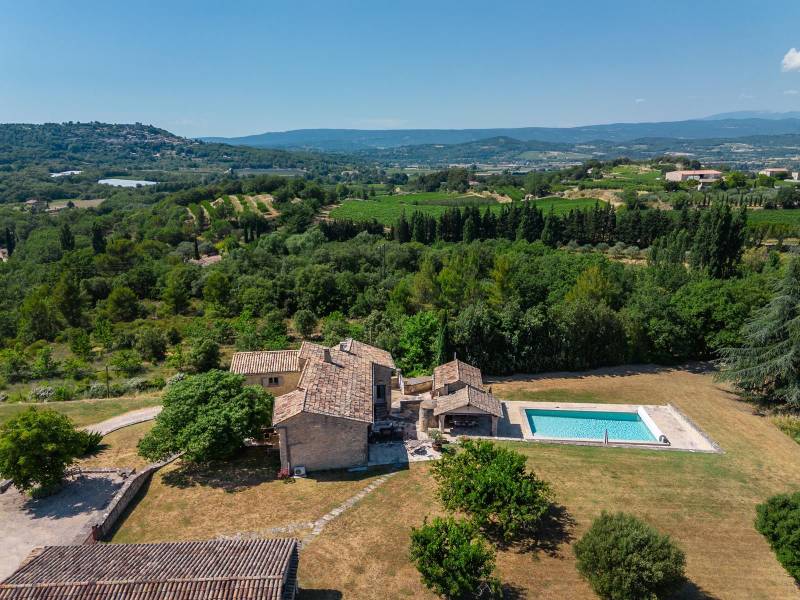 For sale, elegant stone house property with views of Bonnieux and Lacoste, recently restored with high-end amenities and separated annexes.