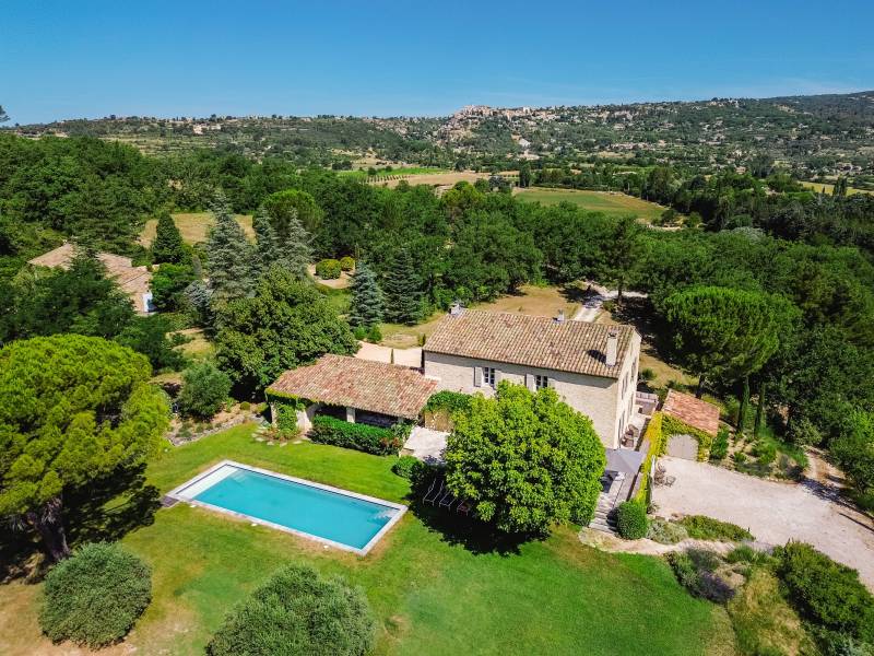 For rent in Gordes, stone Bastide in an elevated position with Luberon views, spacious grounds, and pool.