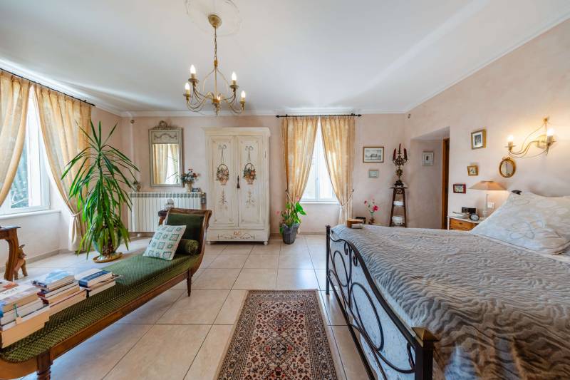 Serene ground-floor bedroom suite with light-flooded windows and direct pool access.