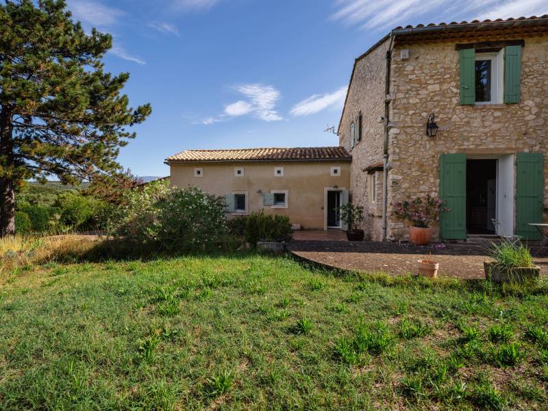 South-facing facade and terraces: the stone farmhouse is revealed within its lush, one-hectare fenced parkland.