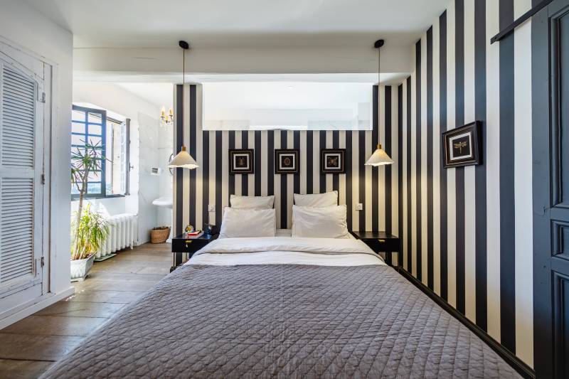 Spacious master bedroom with breathtaking Luberon views, featuring antique parquet flooring and refined finishes.