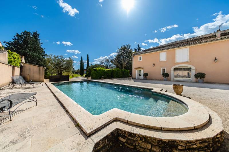 Private stone-edge swimming pool and shaded patio, offering a tranquil retreat in the Provençal countryside.