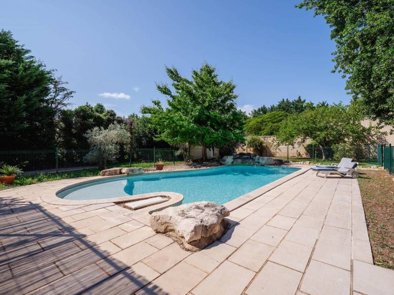 Premium Swimming Area: Free-form Diffazur swimming pool with a waterfall feature, nestled in a beautifully manicured garden.