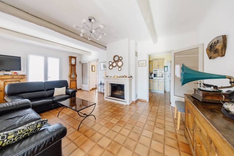 Cozy living room with a fireplace insert, blending Provençal charm with natural light, opening onto the main living area.