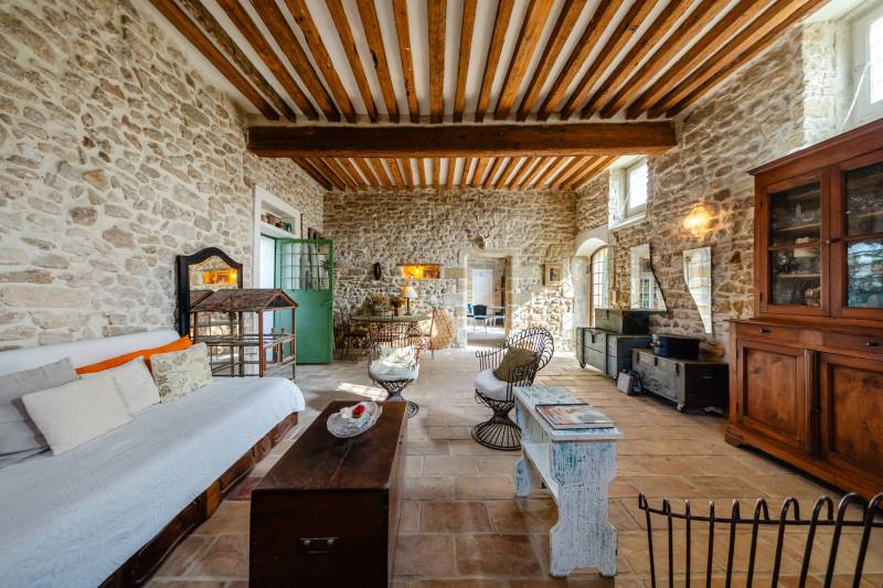 Authentic atmosphere: Through-living room highlighted by exposed stonework and massive beams.