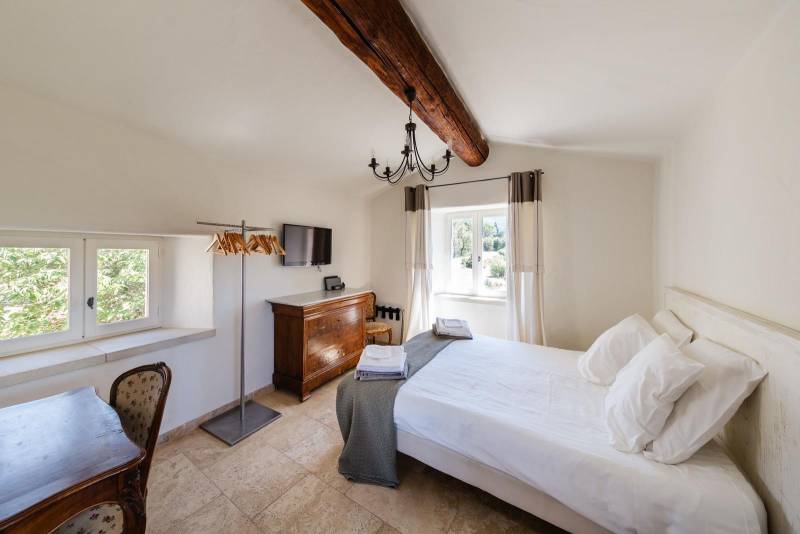For sale, elegant stone house property with views of Bonnieux and Lacoste, recently restored with high-end amenities and separated annexes.