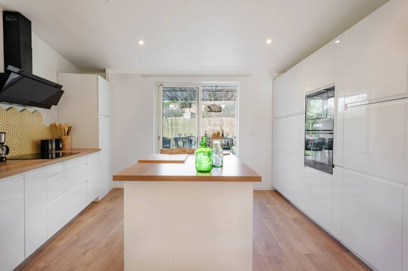 Premium fully-equipped kitchen with a central island, opening onto a shaded north-facing terrace for natural coolness