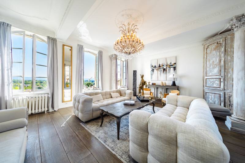 Sophisticated living room featuring an original period fireplace, high ceilings, and authentic crown moldings.
