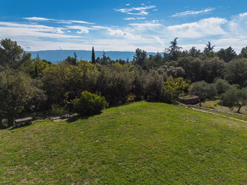 For sale in Cabrières-d’Avignon, stone house in a commanding position with landscaped grounds offering beautiful views of the Luberon.
