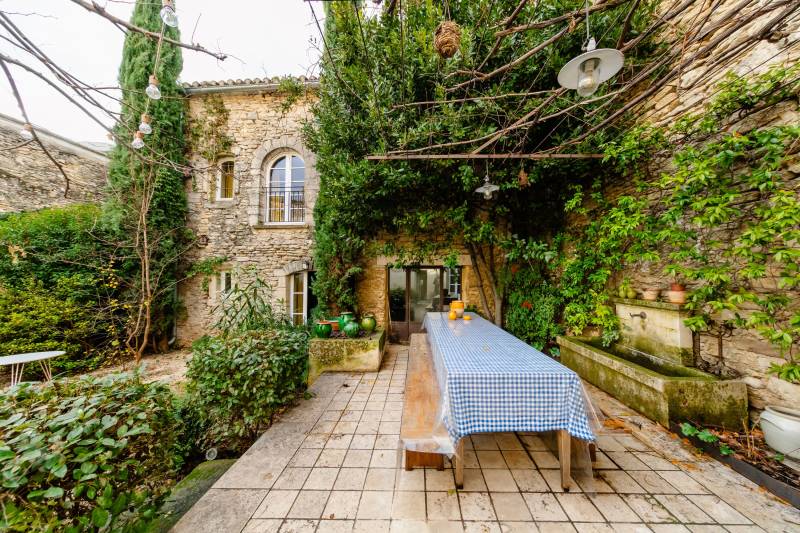 In Gordes, in the heart of a sought-after hamlet, for sale a superb restored 18th-century stone house with two outbuildings set in an enclosed garden featuring a pond.
