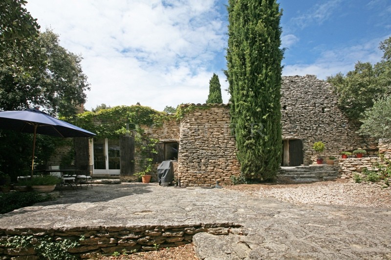 In the Vaucluse mountains and close to the listed village of Gordes: a stone house with outbuildings
