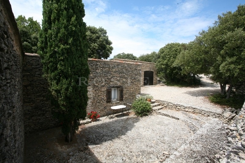 In the Vaucluse mountains and close to the listed village of Gordes: a stone house with outbuildings