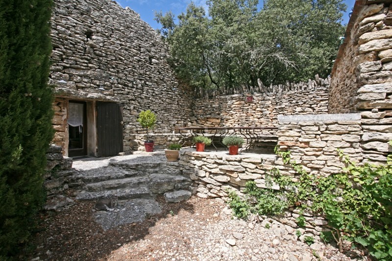In the Vaucluse mountains and close to the listed village of Gordes: a stone house with outbuildings