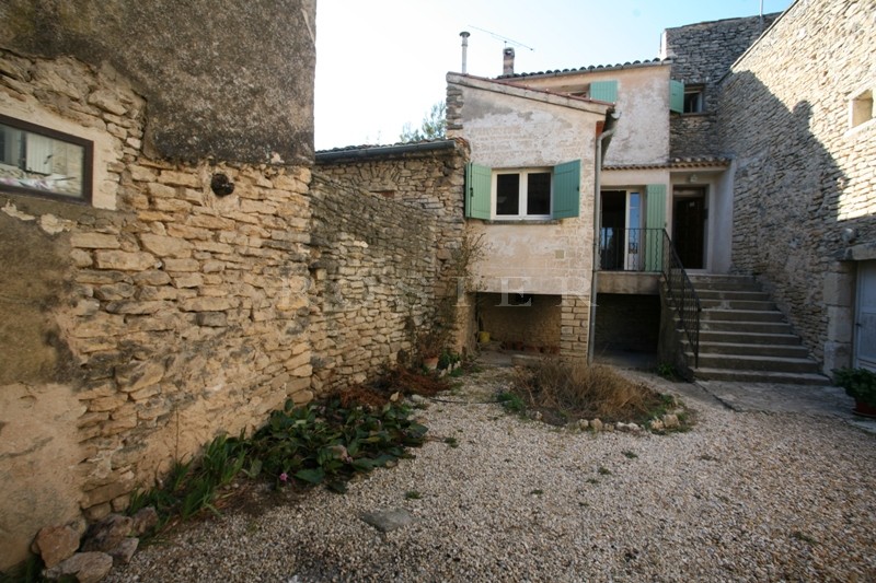 Close to Gordes, in a charming Luberon village, for sale, house with courtyard. Numerous possibilities.