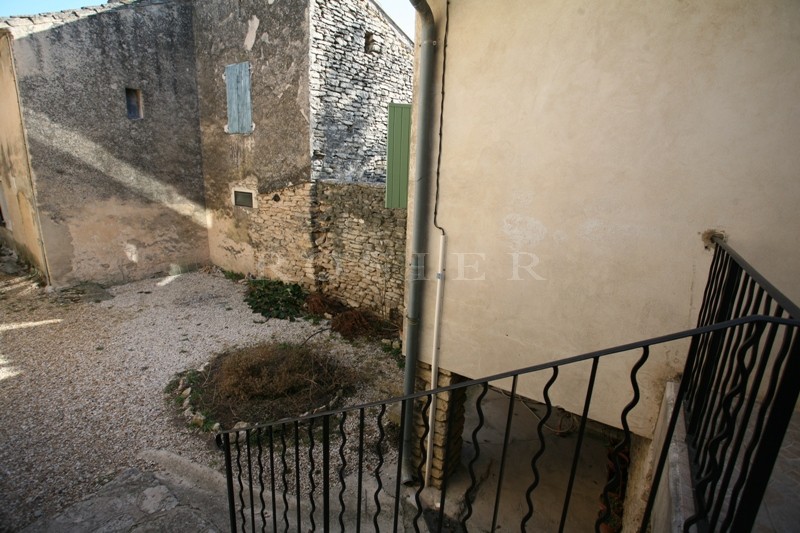 Close to Gordes, in a charming Luberon village, for sale, house with courtyard. Numerous possibilities.