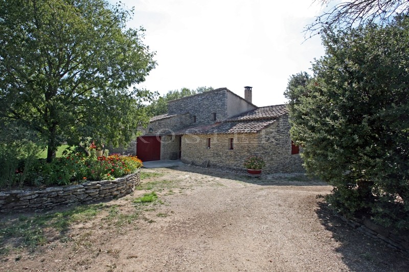 For sale, in a very sought after hamlet near Gordes in Provence, stone-clad house with outbuildings on 5,000 m² of landscaped grounds