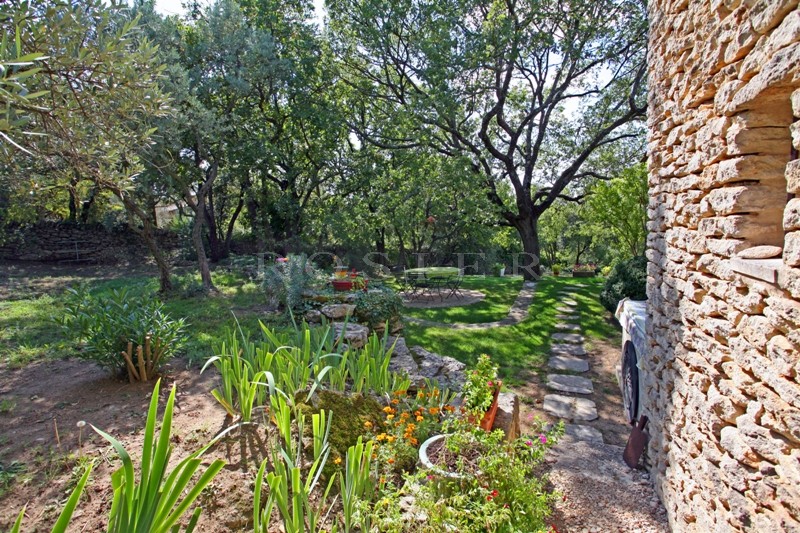 For sale, in a very sought after hamlet near Gordes in Provence, stone-clad house with outbuildings on 5,000 m² of landscaped grounds
