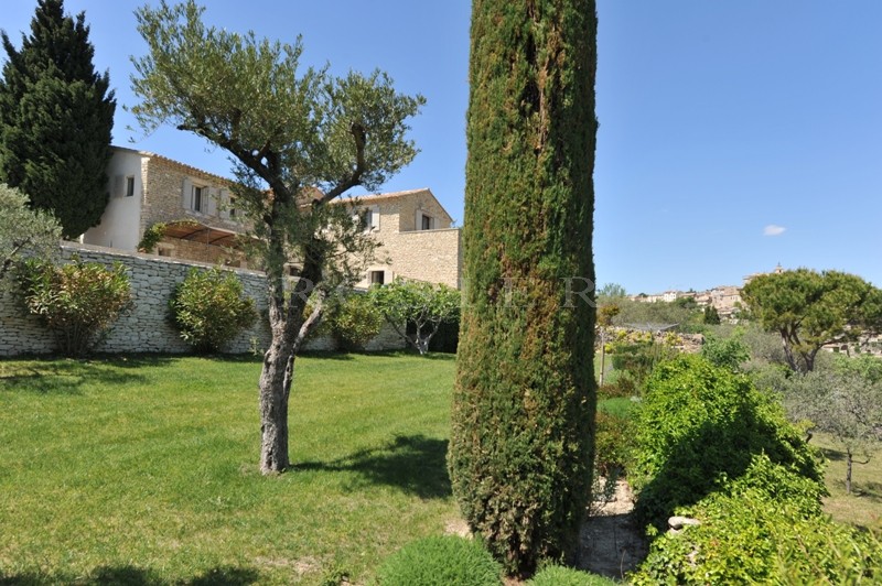 Facing the Luberon mountains, for sale, exceptional provencal property at a walking distance from the centre of Gordes, with landscaped garden and swimming pool.