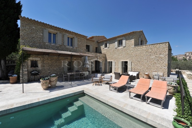 Facing the Luberon mountains, for sale, exceptional provencal property at a walking distance from the centre of Gordes, with landscaped garden and swimming pool.