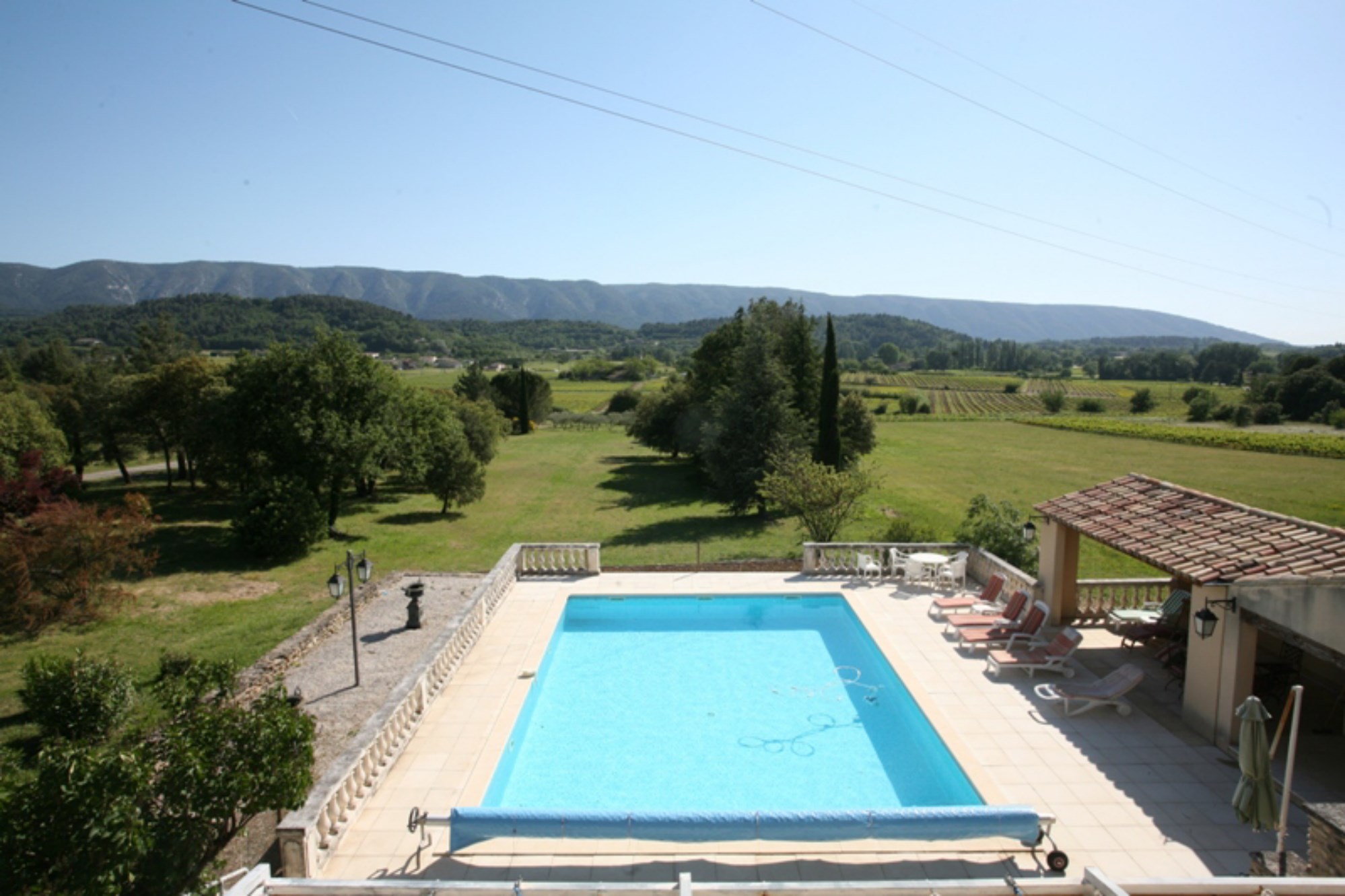 For sale, provencal property with pool and terrace overlooking a vineyard, countryside and facing the Luberon