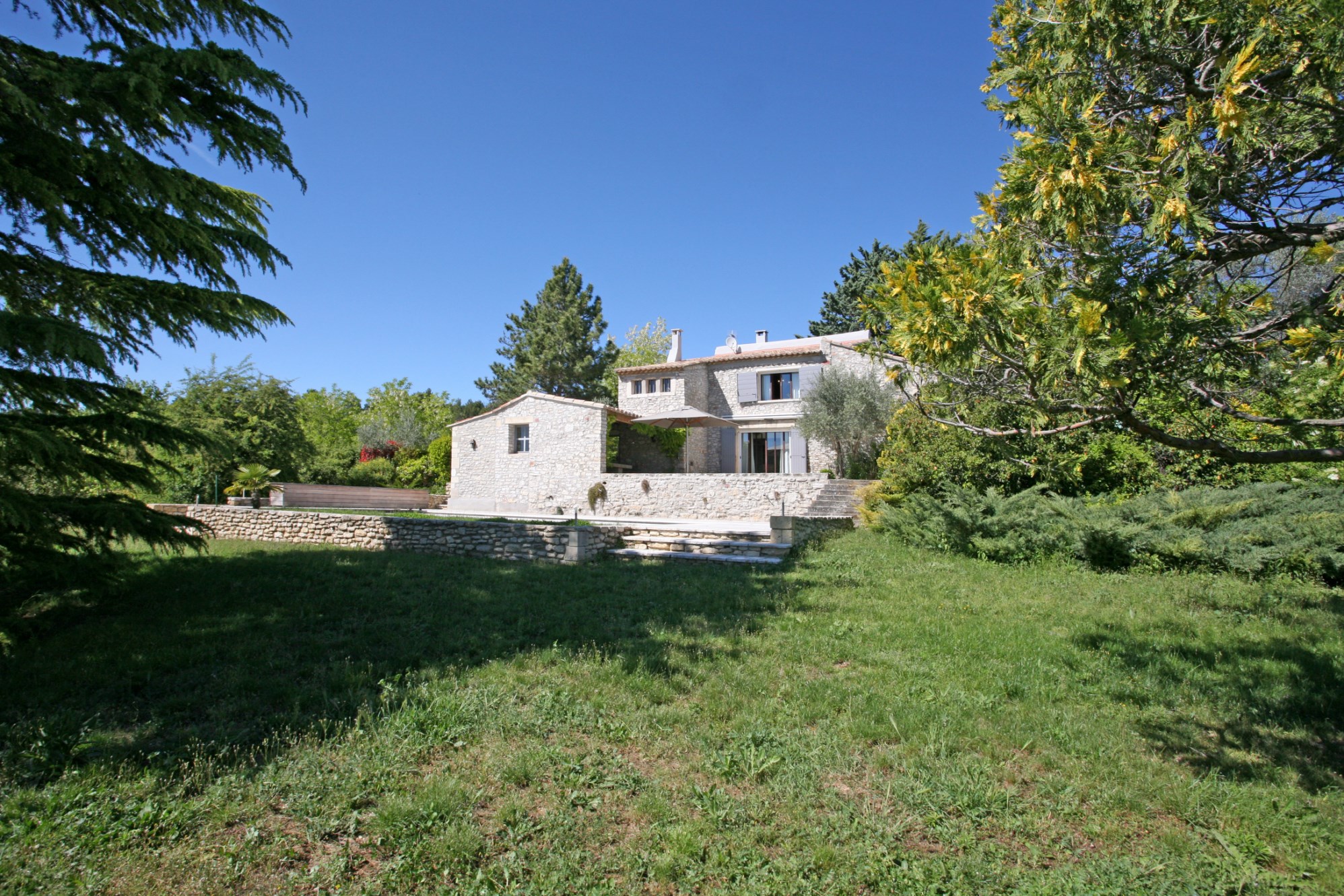 For sale in Luberon, near a superb hilltop village, elegant house with independent studio, park, views and swimming pool